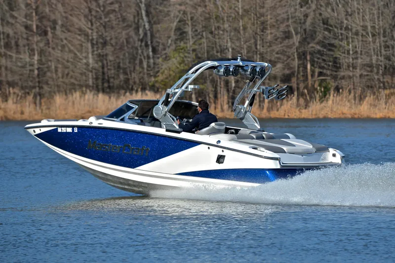 Slide: The Image of 2013 MasterCraft X-35 boat cruising on a lake with trees in the background. - 4