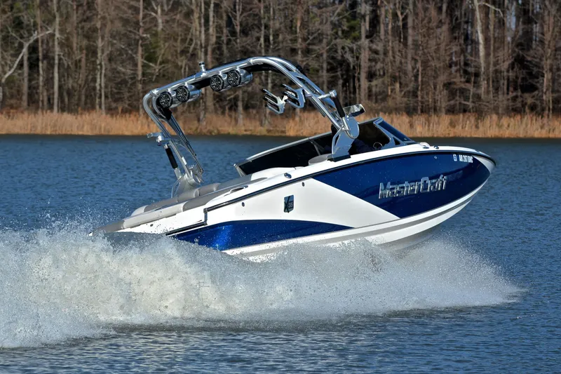 Slide: The Image of 2013 MasterCraft X-35 boat cruising on a lake with forest backdrop. - 5