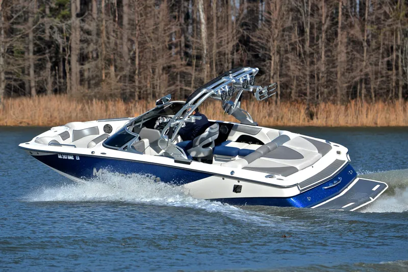 Slide: The Image of 2013 MasterCraft X-35 boat cruising on a lake with forest backdrop. - 6