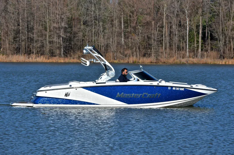 Slide: The Image of 2013 MasterCraft X-35 boat cruising on a lake with a forested background. - 8