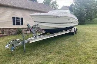 The Image of 2001 Formula 260 Sun Sport boat on trailer beside house, parked on grass. - 0