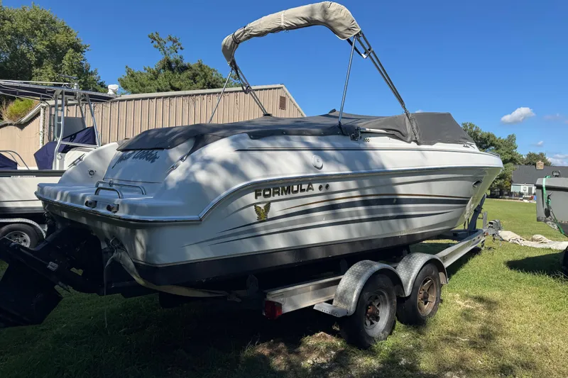Slide: The Image of 2001 Formula 260 Sun Sport boat on trailer, parked outdoors under clear blue sky. - 1