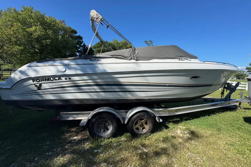 Slide: The Image of 2001 Formula 260 Sun Sport boat on trailer, parked on grass under clear blue sky. - 2