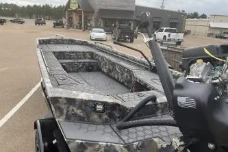 Slide: The Image of 2026 Excel 1751 Shallow Water F4 boat with camouflage design in parking lot. - 1