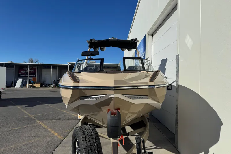 Slide: The Image of 2023 Supra SL 575 boat on trailer, parked outside a building under clear blue sky. - 4