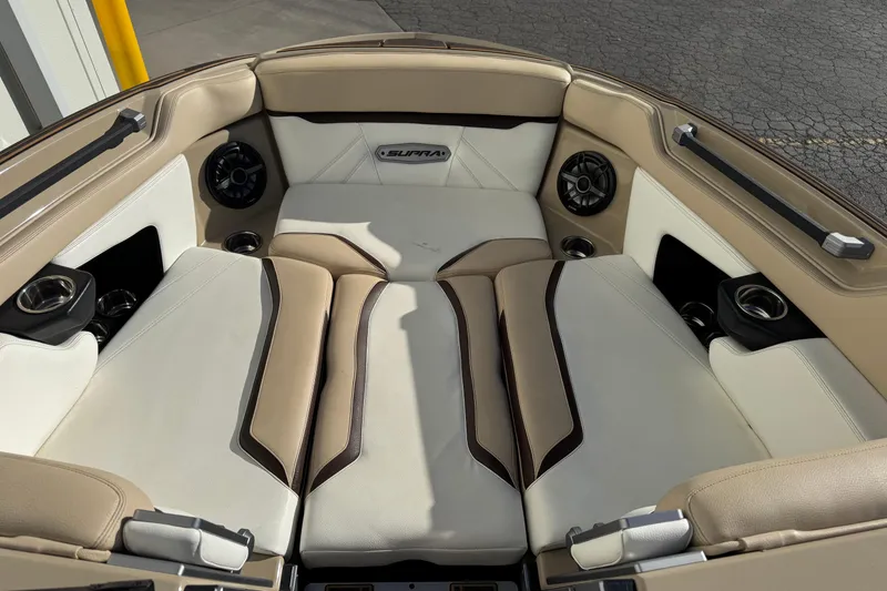 Slide: The Image of 2023 Supra SL 575 boat interior with beige and white seating, cup holders, and speakers. - 5