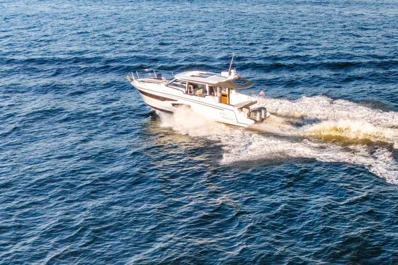 Slide: The Image of 2021 Jeanneau NC 1095 cruising on open water, creating a wake. - 18