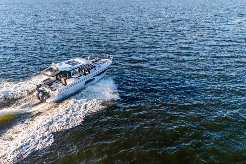 Slide: The Image of 2021 Jeanneau NC 1095 cruising on open water, aerial view. - 22