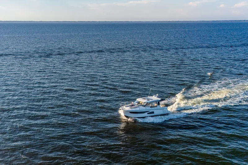 Slide: The Image of 2021 Jeanneau NC 1095 cruising on open water under clear skies. - 7