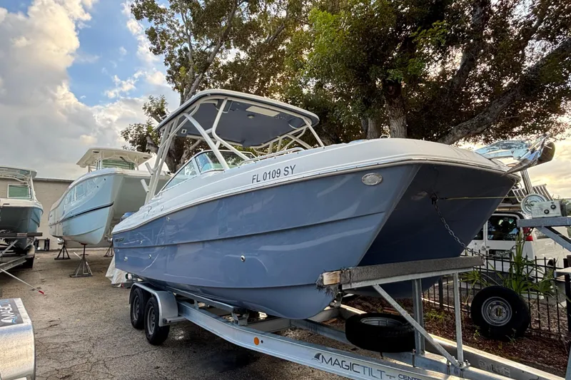 The Image of 2021 World Cat 230 SD boat on trailer, parked outdoors under cloudy sky. - 0