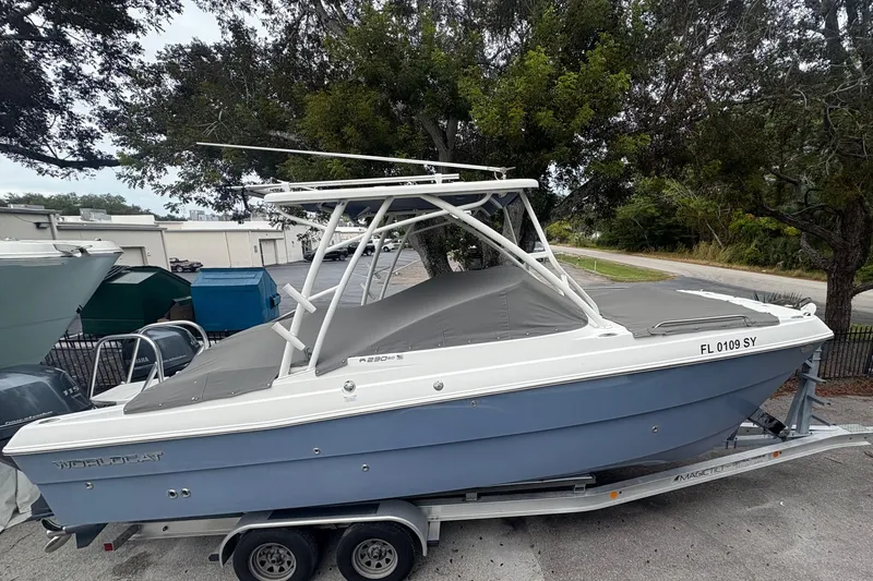 Slide: The Image of 2021 World Cat 230 SD boat on trailer, parked outdoors, covered and ready for transport. - 1
