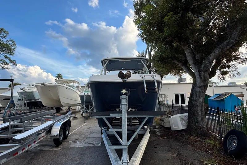 Slide: The Image of 2021 World Cat 230 SD boat on trailer, parked outdoors under a cloudy sky. - 5