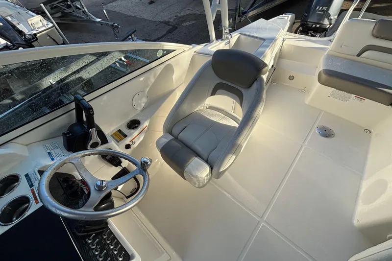 Slide: The Image of 2021 World Cat 230 SD boat interior with steering wheel and seating area. - 6