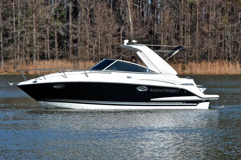 Slide: The Image of 2018 Monterey 275 Sport Yacht cruising on a calm lake with forested background. - 11