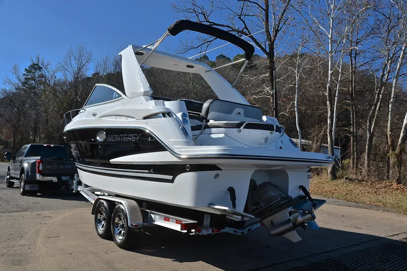 Slide: The Image of 2018 Monterey 275 Sport Yacht on trailer, parked outdoors near trees. - 15