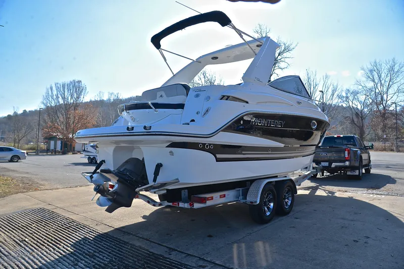 Slide: The Image of 2018 Monterey 275 Sport Yacht on trailer, parked outdoors in a sunny setting. - 17