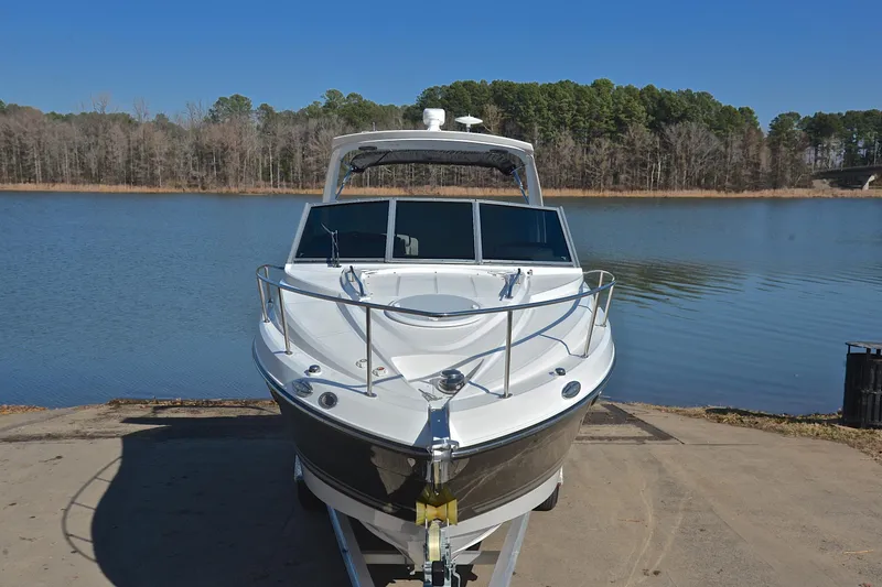 Slide: The Image of 2018 Monterey 275 Sport Yacht on trailer by a serene lake. - 20