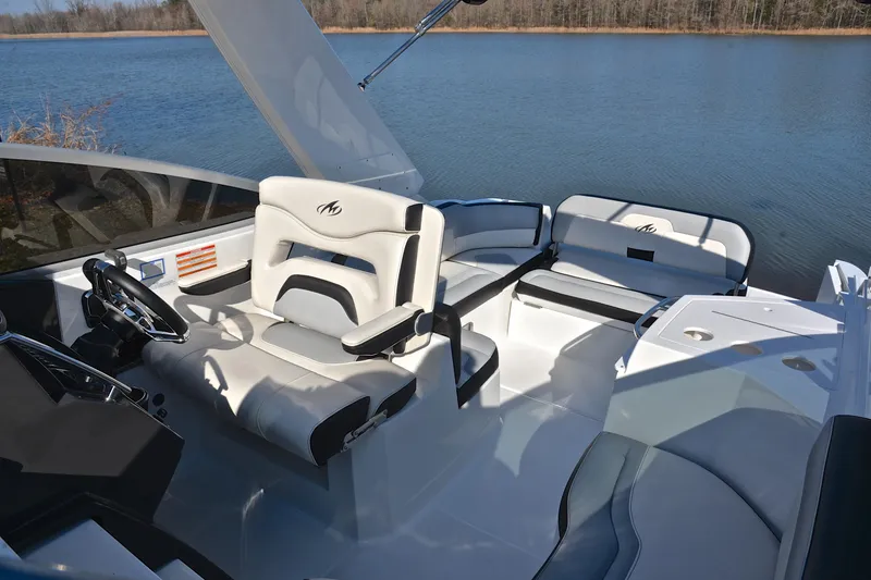 Slide: The Image of 2018 Monterey 275 Sport Yacht interior with sleek seating and steering, overlooking serene water. - 28