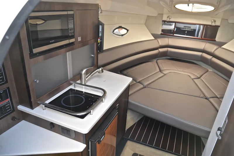 Slide: The Image of 2018 Monterey 275 Sport Yacht interior with kitchenette and cozy seating area. - 33