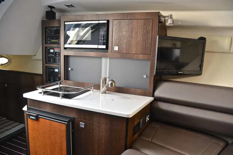Slide: The Image of 2018 Monterey 275 Sport Yacht interior with kitchenette and seating area. - 35