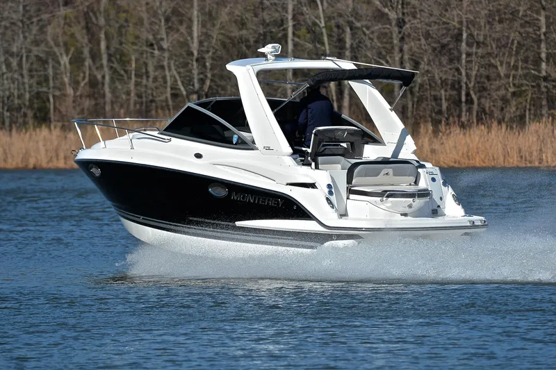 Slide: The Image of 2018 Monterey 275 Sport Yacht cruising on a lake with forested background. - 4