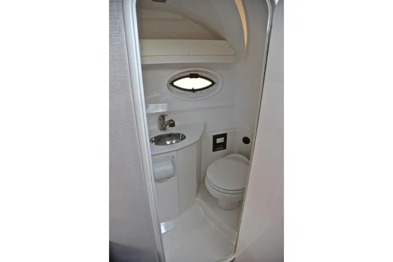 Slide: The Image of Compact bathroom in 2018 Monterey 275 Sport Yacht with sink, toilet, and porthole window. - 43