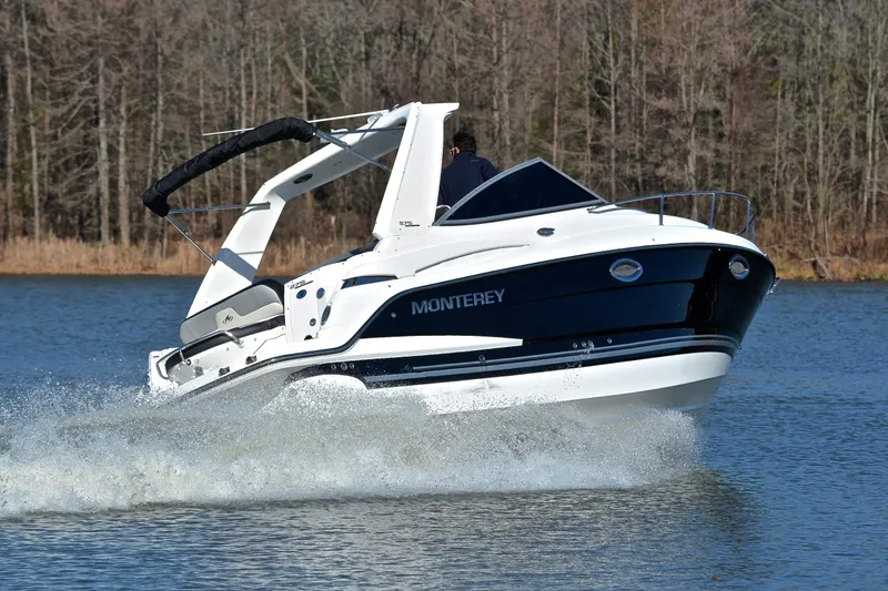 Slide: The Image of 2018 Monterey 275 Sport Yacht cruising on a lake with forested background. - 5