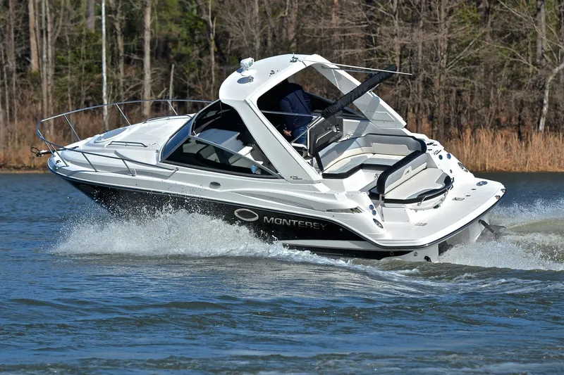 Slide: The Image of 2018 Monterey 275 Sport Yacht cruising on a lake with forested background. - 6