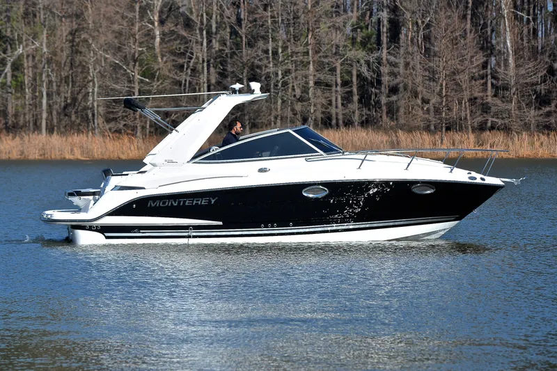 Slide: The Image of 2018 Monterey 275 Sport Yacht cruising on a serene lake with forest backdrop. - 8