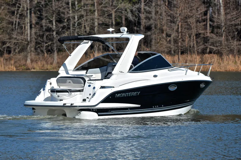 Slide: The Image of 2018 Monterey 275 Sport Yacht cruising on a calm lake with forested background. - 9