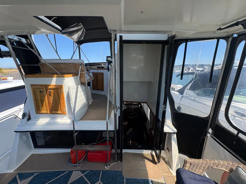 Slide: The Image of 1988 Carver 36 Aft Cabin interior with wooden cabinets and marina view. - 10