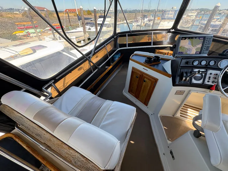 Slide: The Image of 1988 Carver 36 Aft Cabin helm with navigation equipment and marina view. - 11