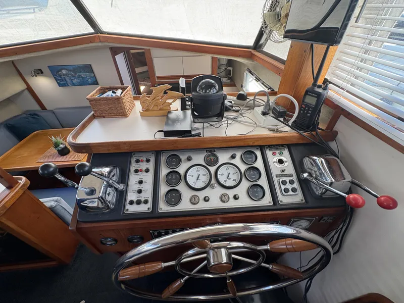 Slide: The Image of 1988 Carver 36 Aft Cabin helm with gauges, controls, and nautical decor. - 24