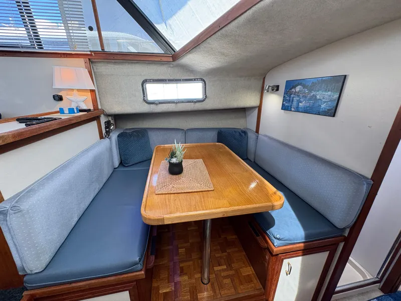 Slide: The Image of 1988 Carver 36 Aft Cabin interior with cozy dining area and wooden table. - 28
