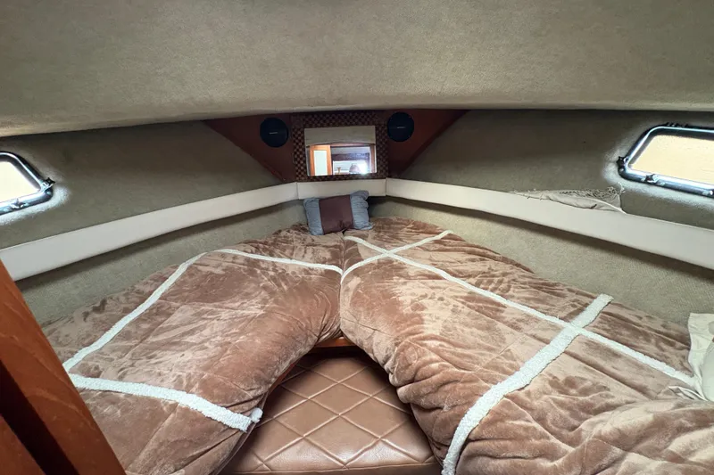 Slide: The Image of Cozy cabin interior of 1988 Carver 36 Aft Cabin with plush bedding and porthole windows. - 32
