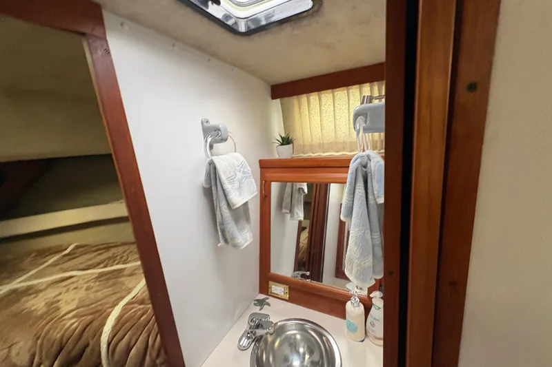 Slide: The Image of Compact bathroom in 1988 Carver 36 Aft Cabin with sink, mirror, and towels. - 34