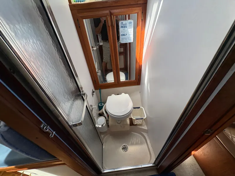 Slide: The Image of 1988 Carver 36 Aft Cabin bathroom with shower, toilet, and mirror. - 37