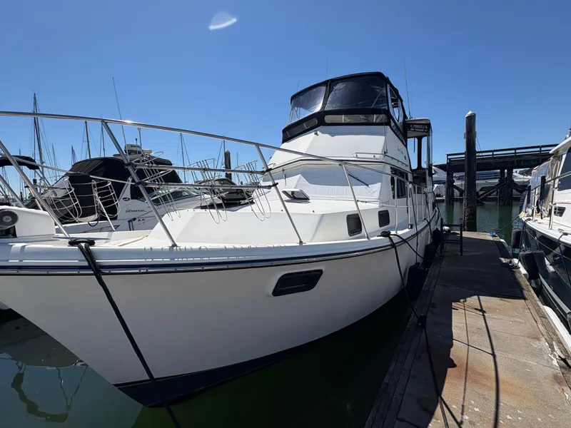 Slide: The Image of 1988 Carver 36 Aft Cabin yacht docked at marina under clear blue sky. - 4