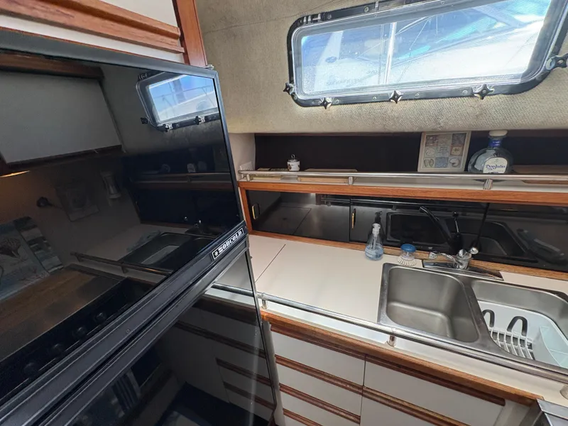 Slide: The Image of 1988 Carver 36 Aft Cabin kitchen with sink, window, and appliances. - 40