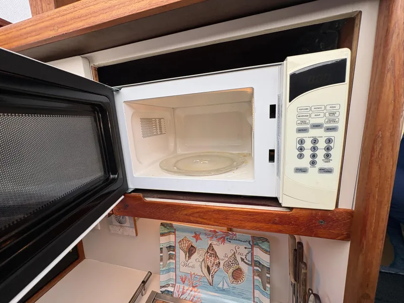 Slide: The Image of Microwave in 1988 Carver 36 Aft Cabin yacht kitchen with open door and control panel. - 41