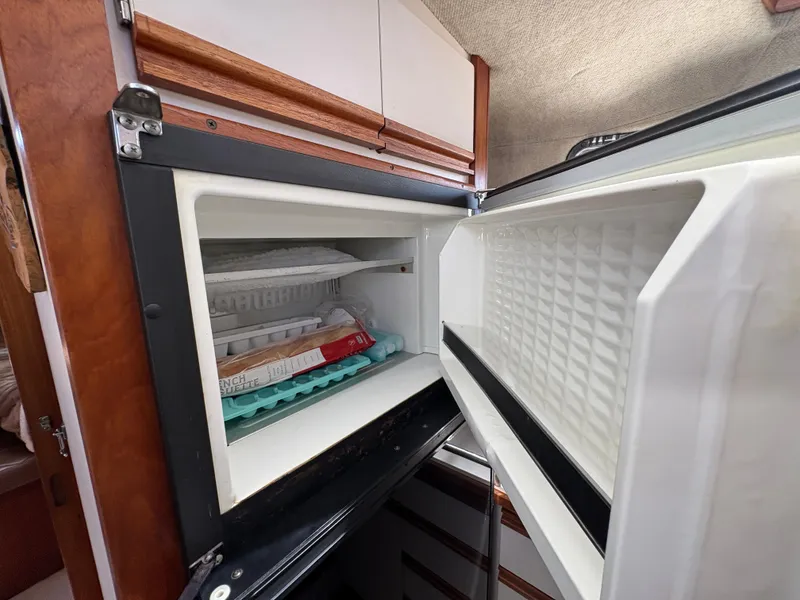 Slide: The Image of Open freezer in 1988 Carver 36 Aft Cabin yacht, showing ice trays and food items. - 44