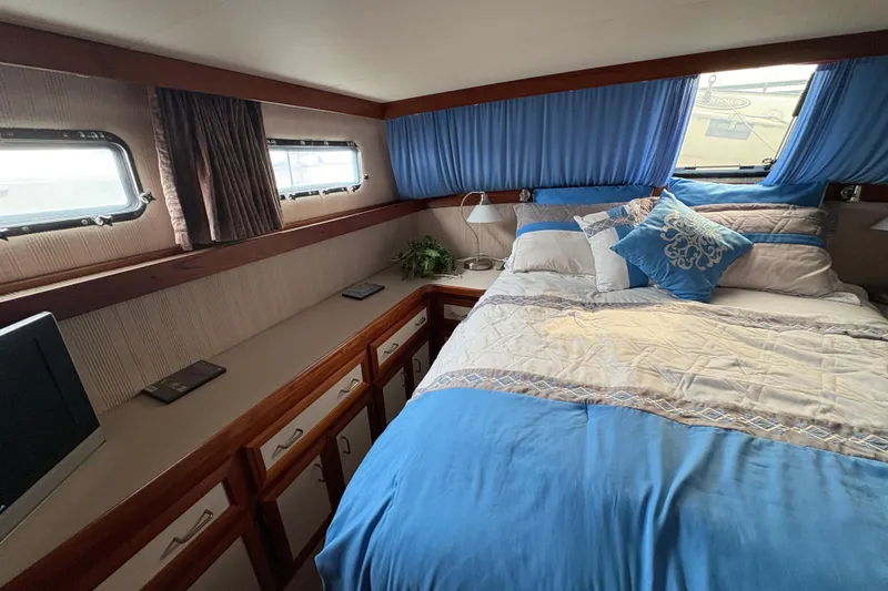 Slide: The Image of Cozy bedroom in 1988 Carver 36 Aft Cabin with blue bedding and natural light. - 47