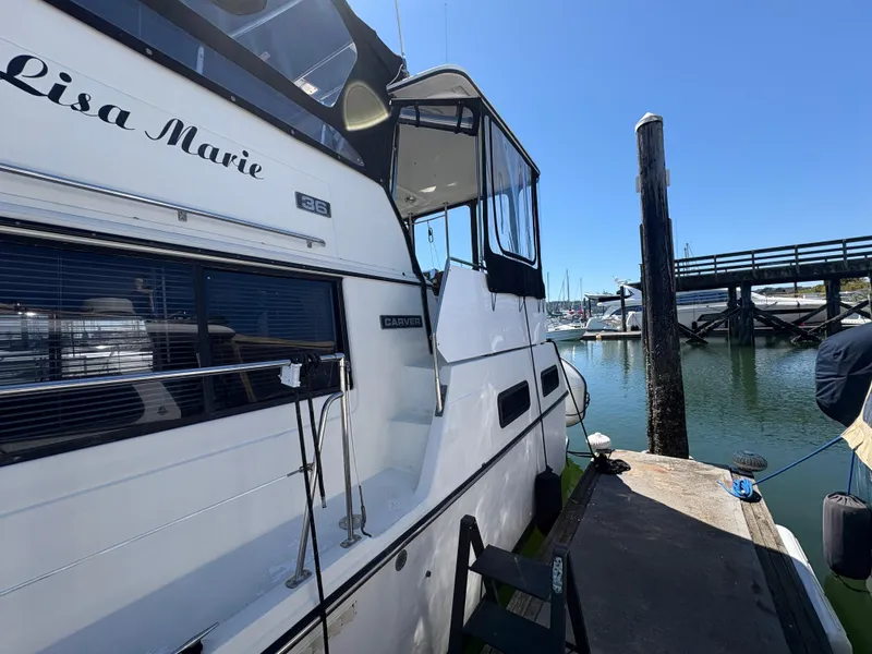 Slide: The Image of 1988 Carver 36 Aft Cabin yacht docked at marina under clear blue sky. - 5