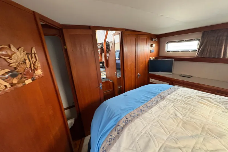 Slide: The Image of 1988 Carver 36 Aft Cabin interior with wood paneling and cozy bed. - 53