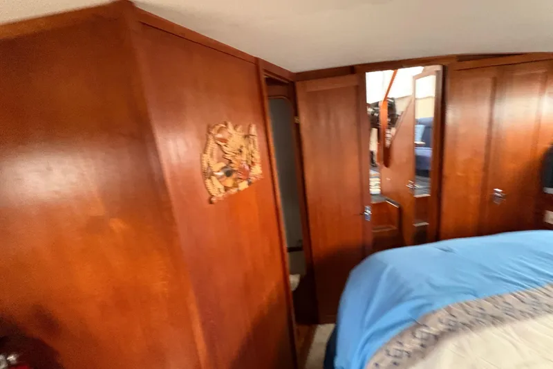 Slide: The Image of Interior of 1988 Carver 36 Aft Cabin with wooden paneling and blue bedding. - 54
