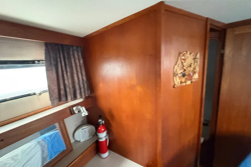 Slide: The Image of 1988 Carver 36 Aft Cabin interior with wood paneling and window. - 55