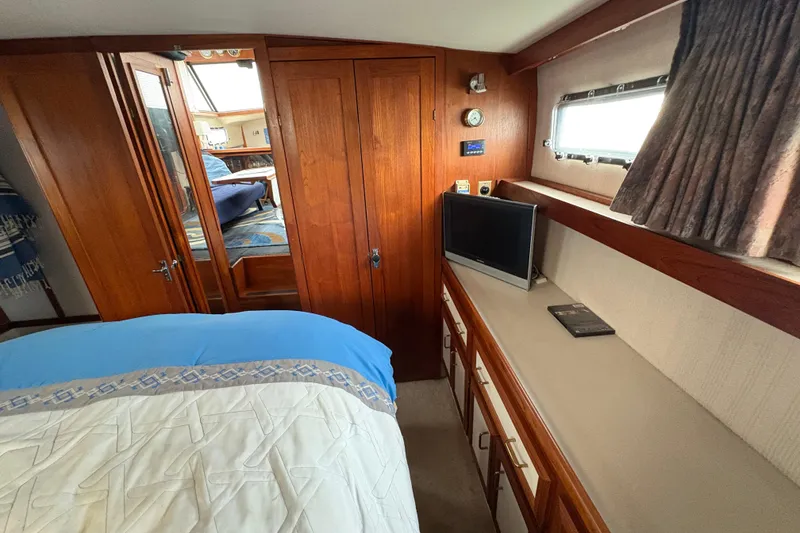 Slide: The Image of 1988 Carver 36 Aft Cabin interior with wood paneling, bed, and small TV. - 56