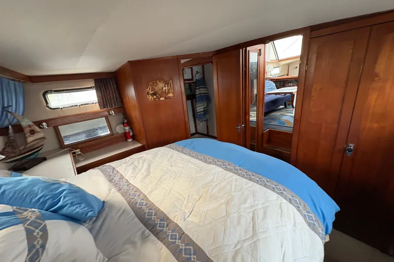 Slide: The Image of 1988 Carver 36 Aft Cabin interior with cozy bed, wooden cabinets, and nautical decor. - 57