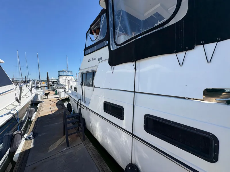 Slide: The Image of 1988 Carver 36 Aft Cabin yacht docked at marina under clear blue sky. - 6