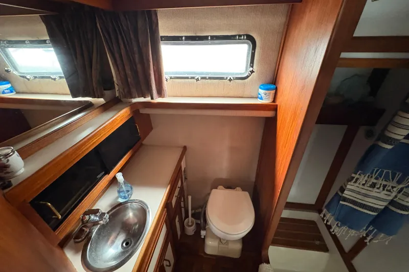 Slide: The Image of 1988 Carver 36 Aft Cabin bathroom with sink, toilet, and window. - 60